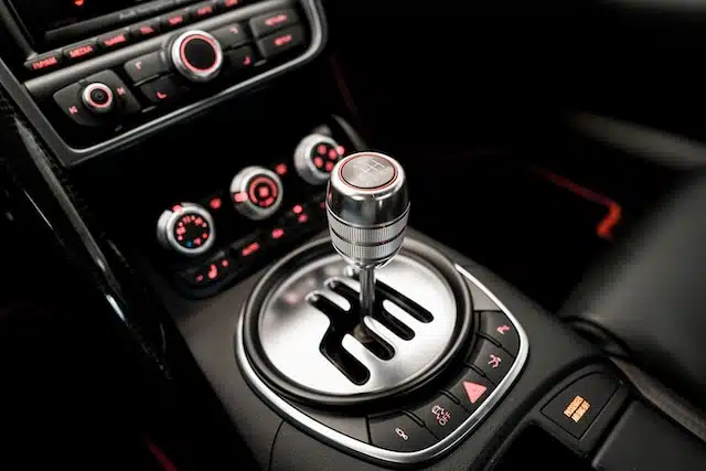 Close-up view of a manual transmission stick shift, associated with an underlying issue of a squeaky clutch pedal.